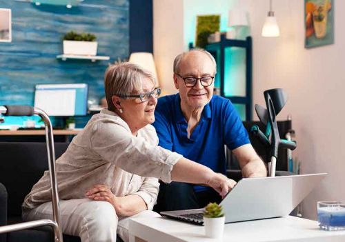 couple looking through home care faq on laptop